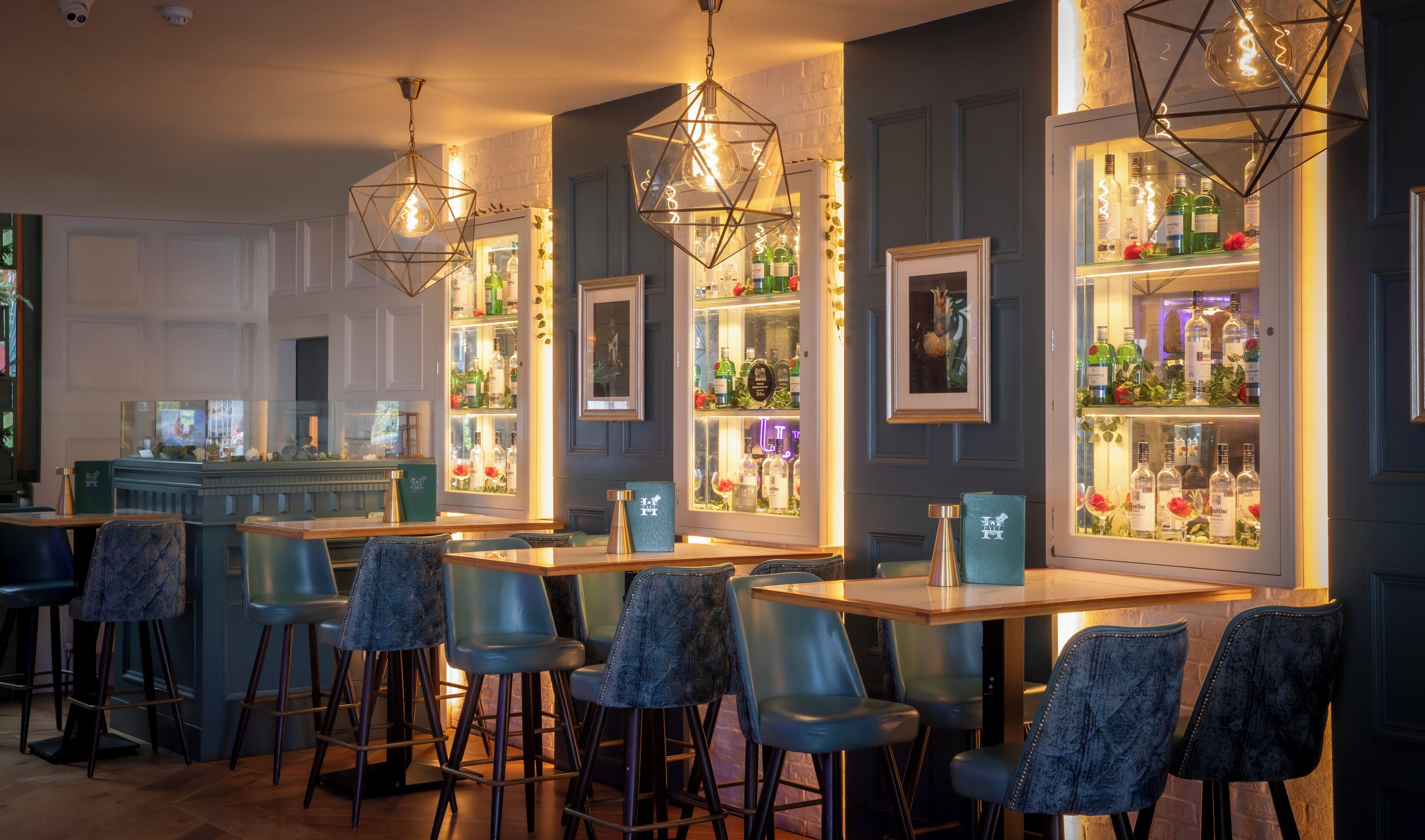 A bar area with multiple seating arrangements, bar counters, and decorative lighting fixtures.