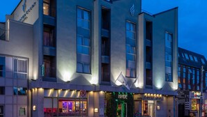 Ein modernes Hotel mit einer markanten Fassade, zahlreichen Fenstern und guter Beleuchtung.
