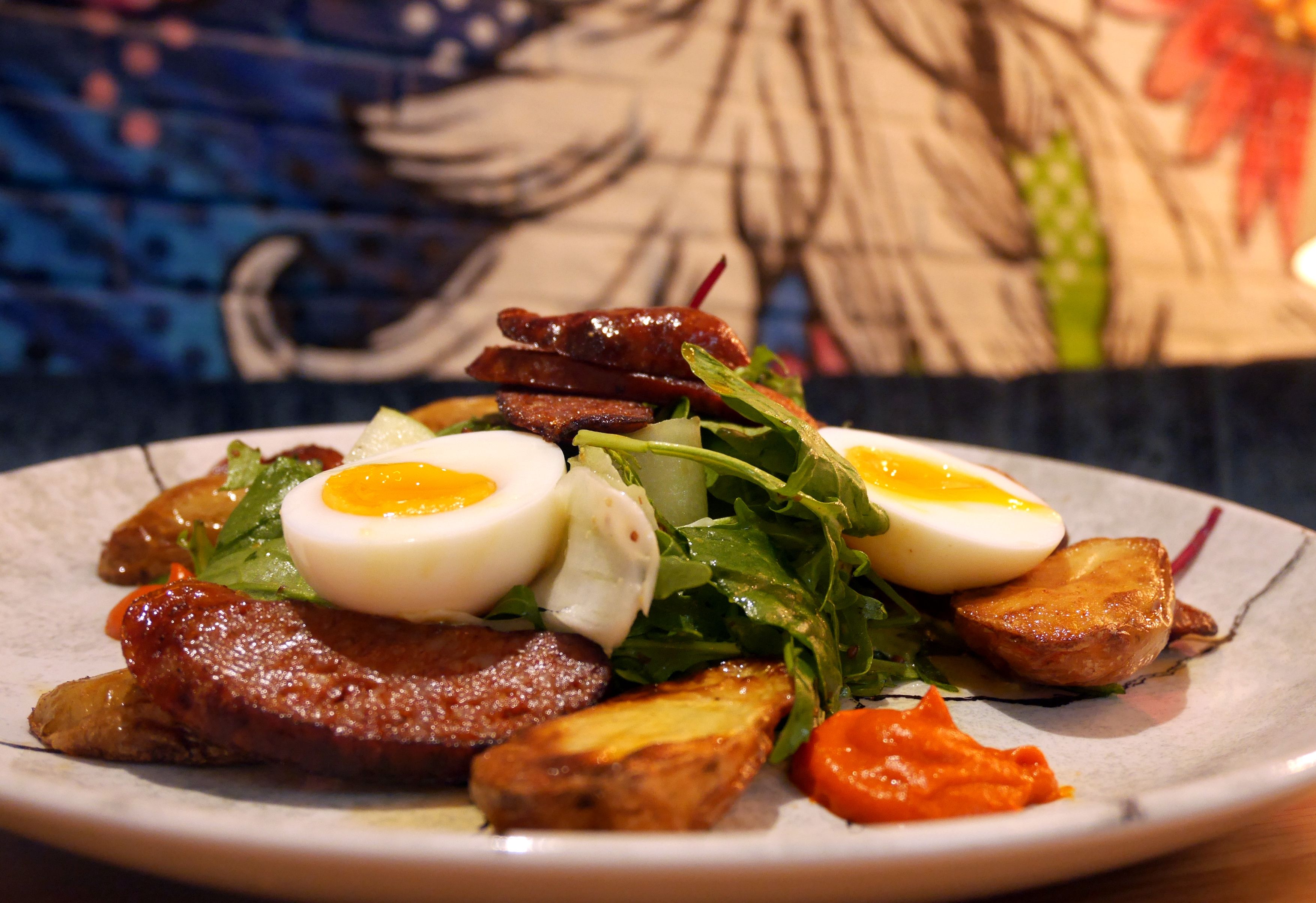 A plate of food with eggs, meat, and vegetables.