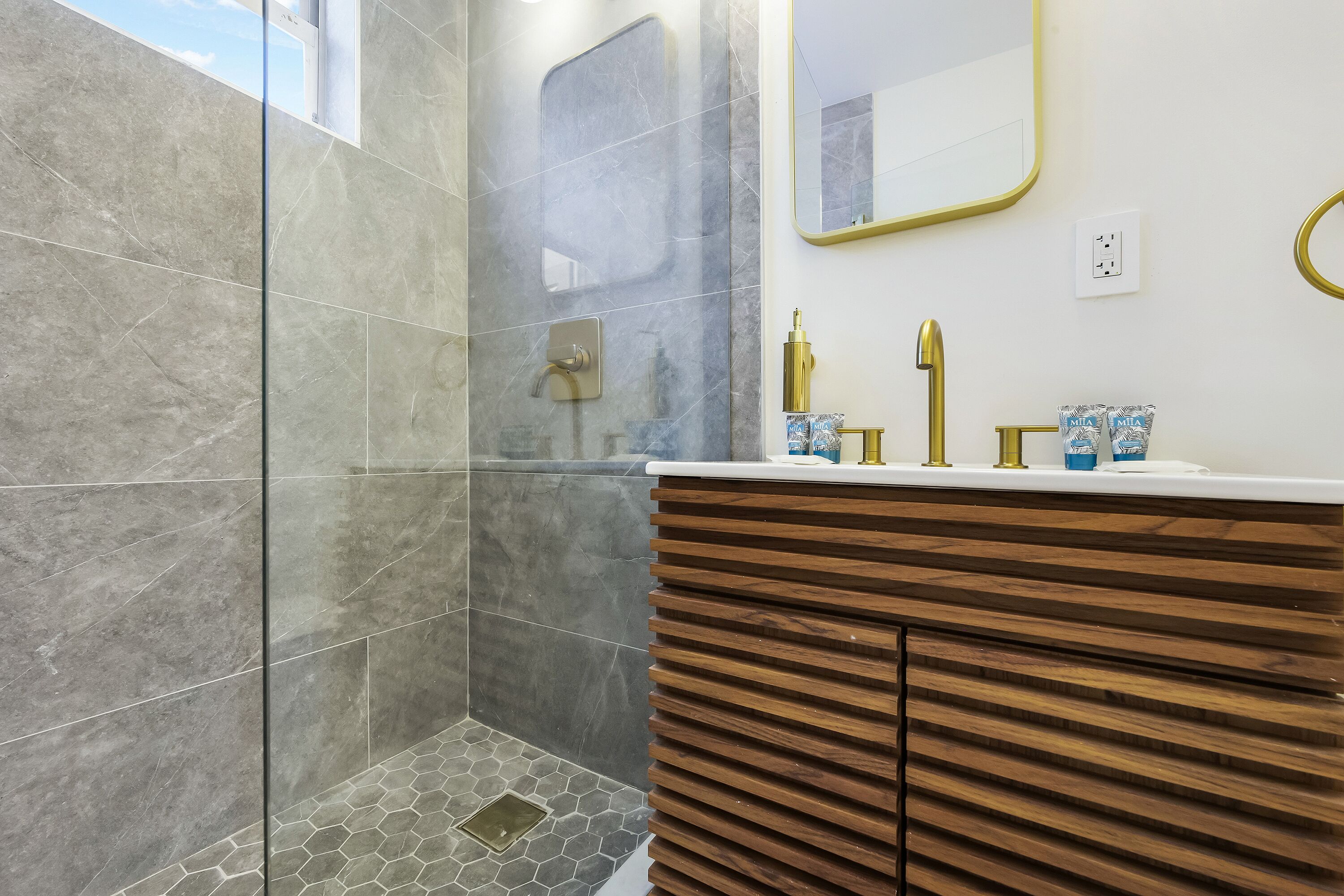 Un baño moderno con ducha, tocador y espejo.