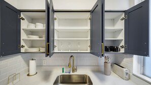 A kitchen with open cabinets, a stainless steel sink, and a toaster. - Harding 8040 Apts By At Mine Hospitality (Miami Beach)