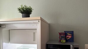 Eine Küche mit Mikrowelle, einem Nutella-Glas und einer Packung Barilla-Pasta.