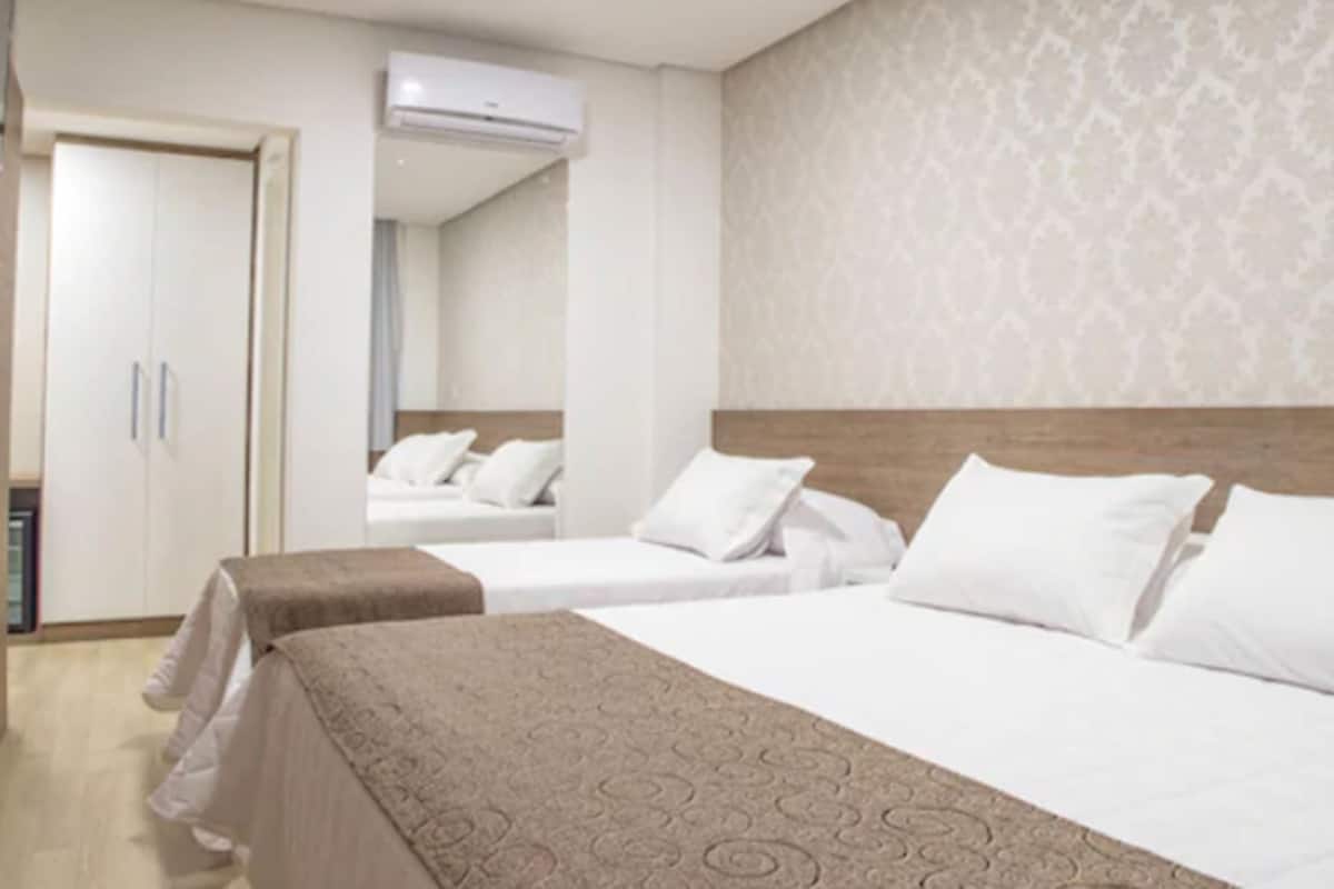 Ein Hotelzimmer mit zwei Betten, einem Kleiderschrank und einer Klimaanlage.