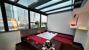A modern rooftop lounge with a hot tub, red cushions, and candles. - Holiday & Business Hotel - Ao lado do Centro de Eventos e Arena Conda (Chapecó)