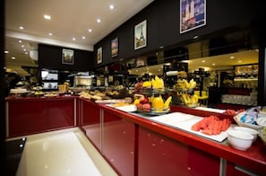 Un buffet proposant une variété de plats et un comptoir rouge.
