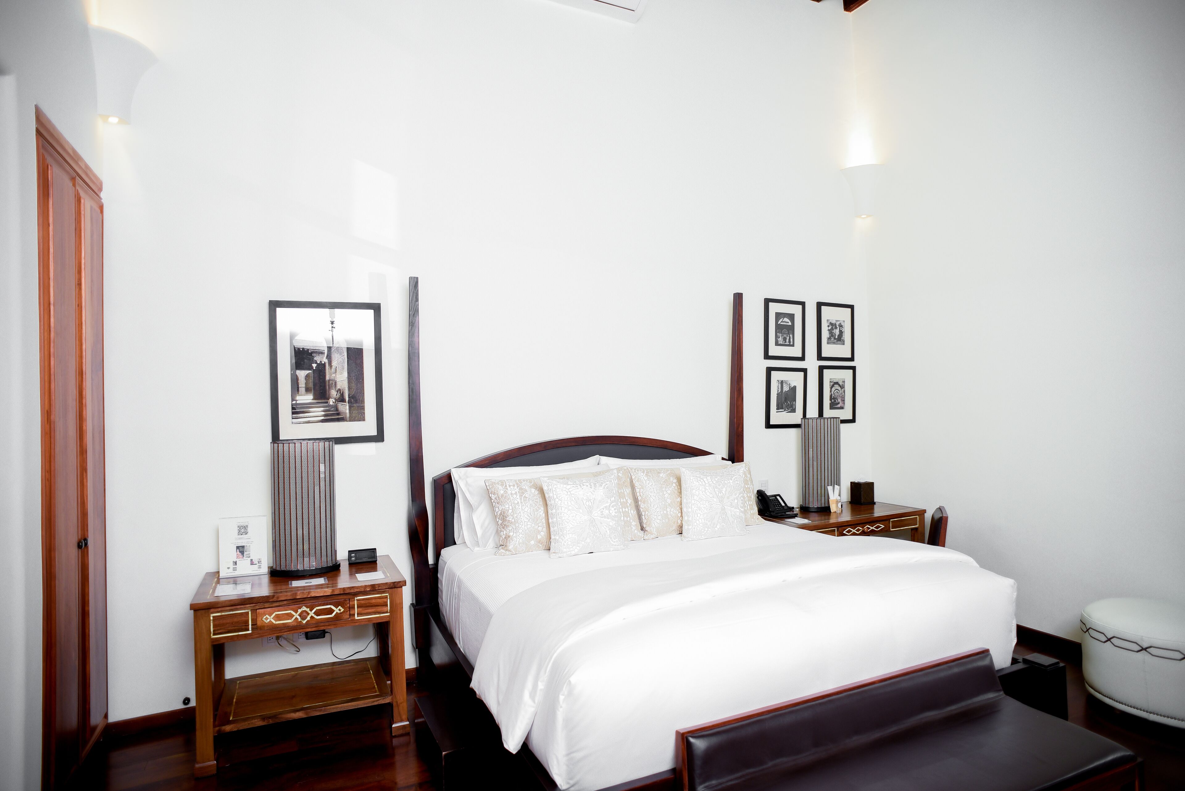 A neatly arranged hotel room with a large bed, bedside tables, a desk, and a chair.