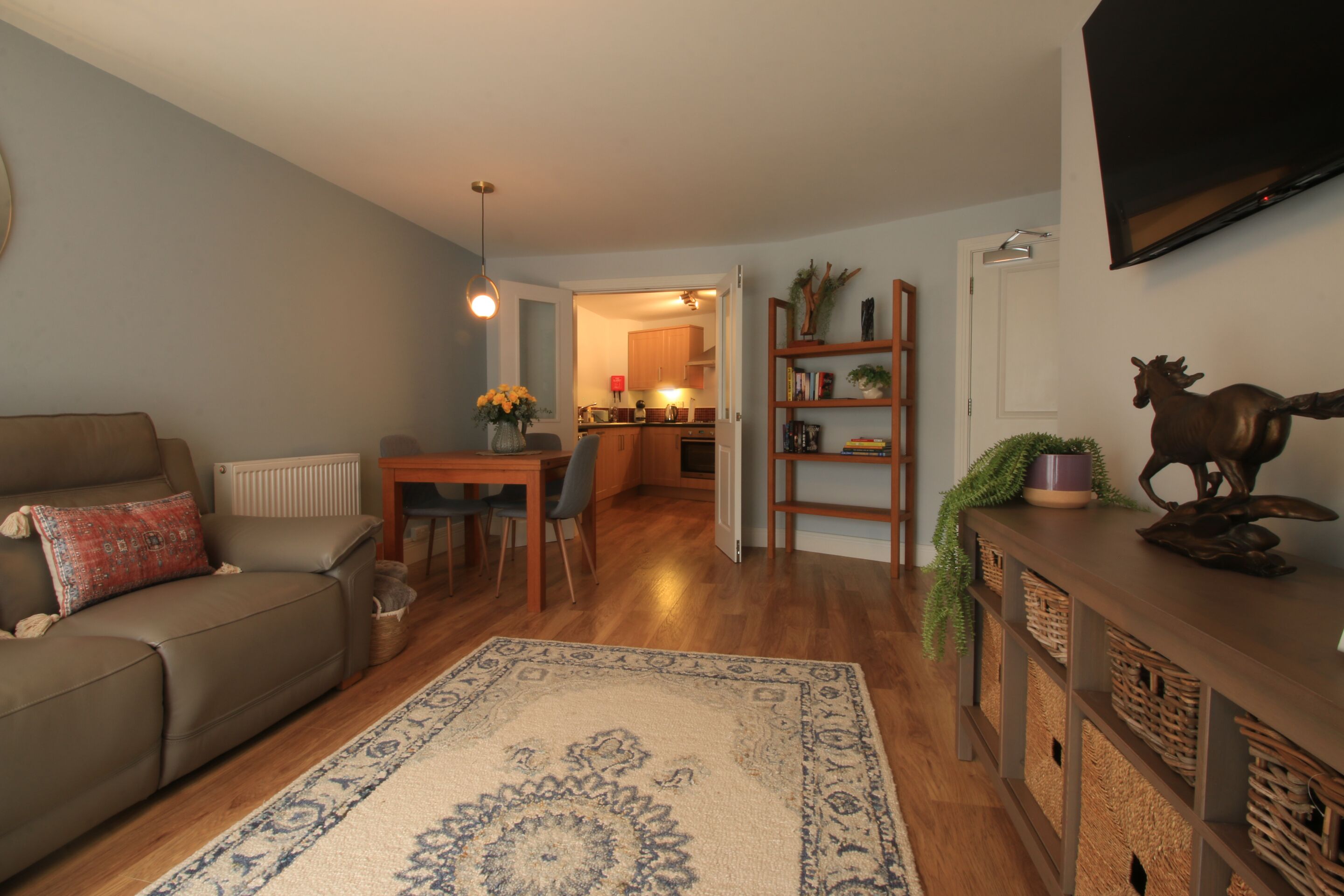 Un salon comprenant un canapé, une table basse, un tapis et un coin repas avec des chaises et une table.
