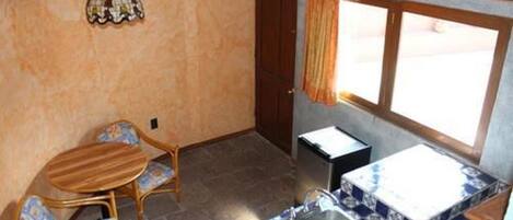 A compact kitchen with a sink, a small table, and two chairs.