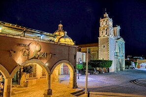 A historic building with a prominent bell tower and a dome, featuring an archway entrance and a sign reading "Hotel La Plaza". - Hotel La Plaza de Tequisquiapan (Tequisquiapan)