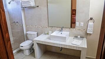 Un baño moderno con ducha, inodoro y lavamanos.