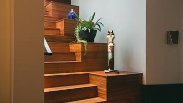 A wooden staircase with a potted plant and a decorative horse statue.