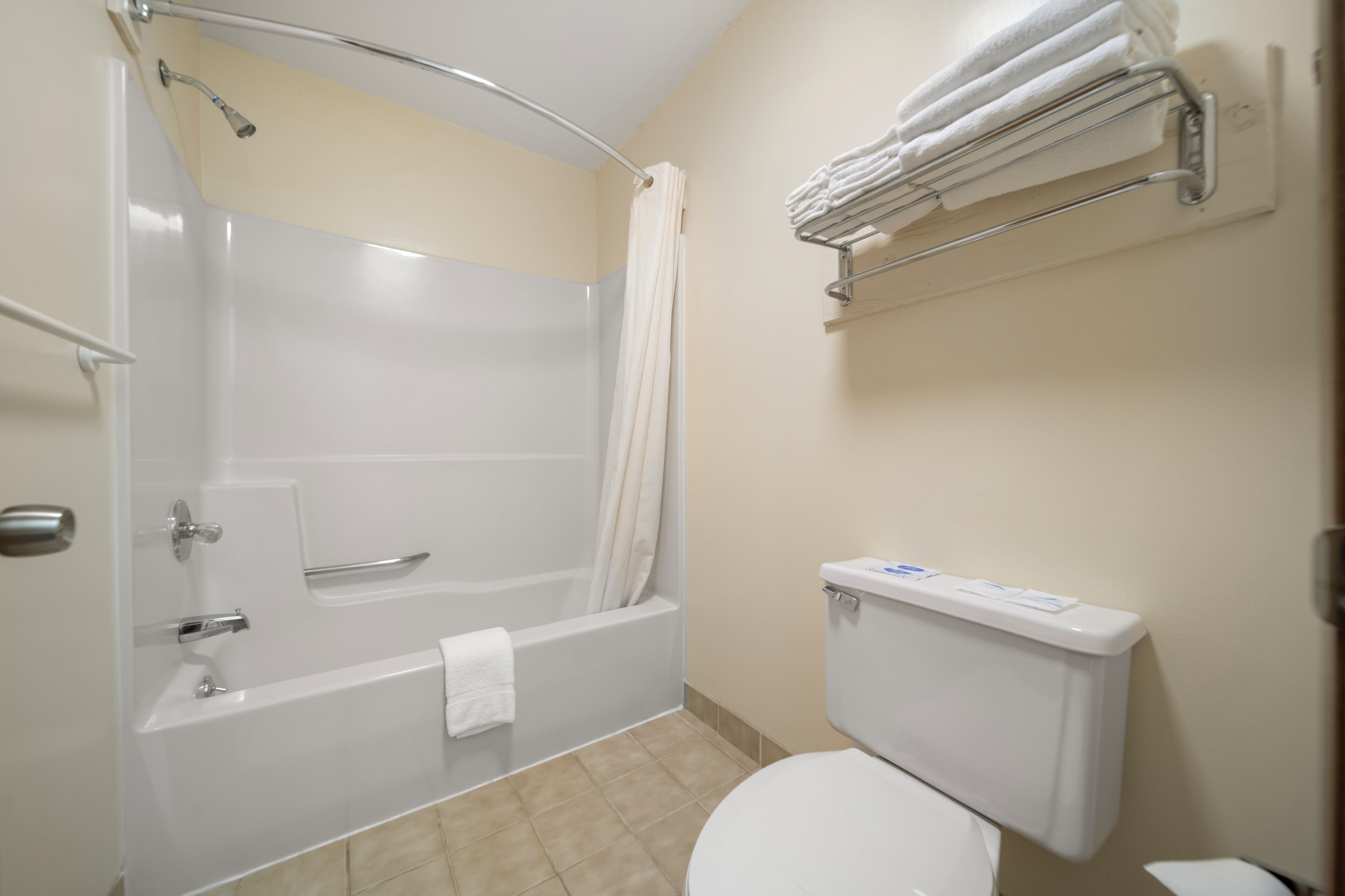 Un baño con bañera, inodoro y toallero.