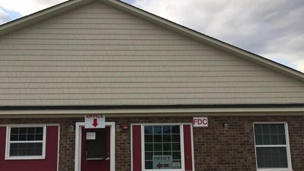 A building with a red door and windows, labeled "OFFICE" and "FDC".