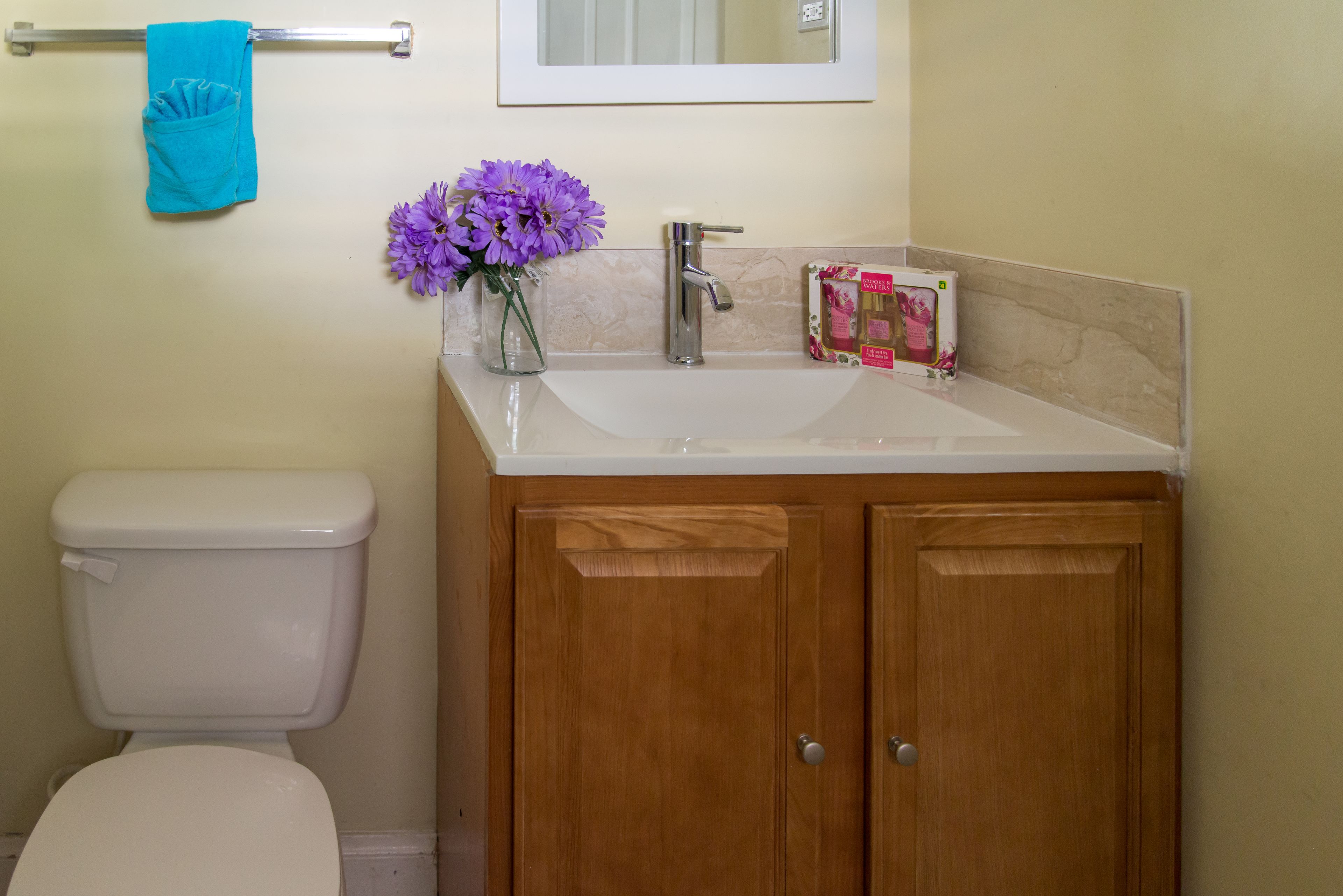 A bathroom with a toilet, sink, and wooden cabinets.