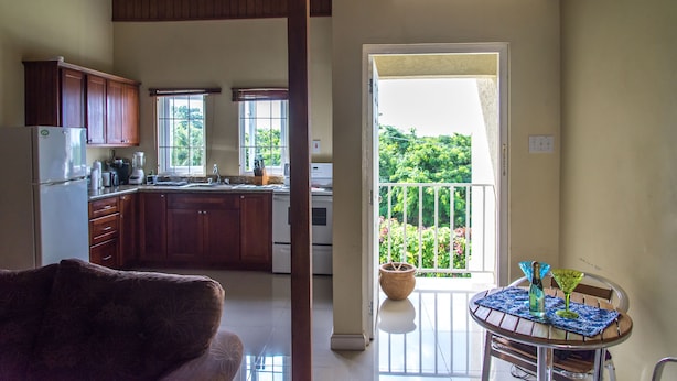 A spacious kitchen with wooden cabinets, a refrigerator, and a dining area with a table and chairs.