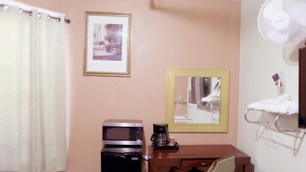 A hotel room with a microwave, coffee maker, and a small table with a chair. - Oak Hotel (San Francisco)