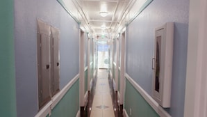A long, narrow hallway with lockers on both sides and a tiled floor.