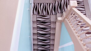 A close-up of a patterned wall with a textured design, a wooden railing, and a light-colored door frame. - Oak Hotel (San Francisco)