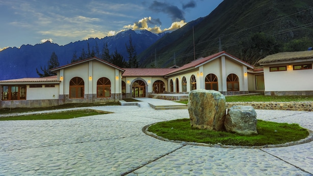 Un bâtiment doté d’une cour intérieure, d’un chemin pavé de pierres et de gros rochers.