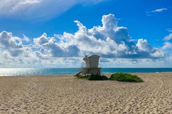 En la playa, sillas reclinables de playa, sombrillas, toallas de playa