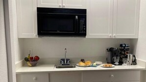 A compact kitchen with a microwave, sink, and a dish drying rack. - Quiet Island Sanctuary, Private Studio, Sleep Deep, Walk to Beach (Vero Beach)