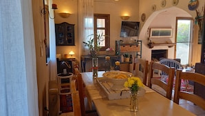 Un salon chaleureux avec une cheminée, des meubles en bois et un téléviseur fixé au mur.