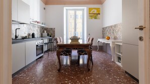 A compact kitchen with a dining table, chairs, and a window.