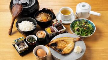 Eine traditionelle japanische Mahlzeit mit Reis, Suppe, Fisch und Tee auf einem Holztisch.