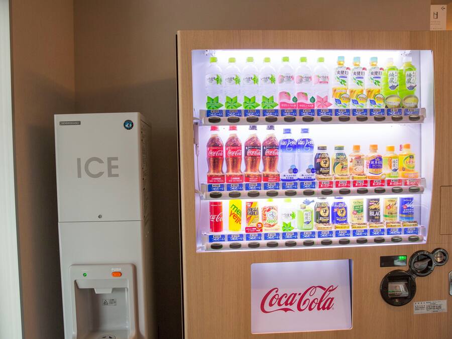 A vending machine with various drinks and a Coca-Cola machine beside it.