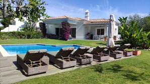 A poolside area with lounge chairs and a swimming pool.