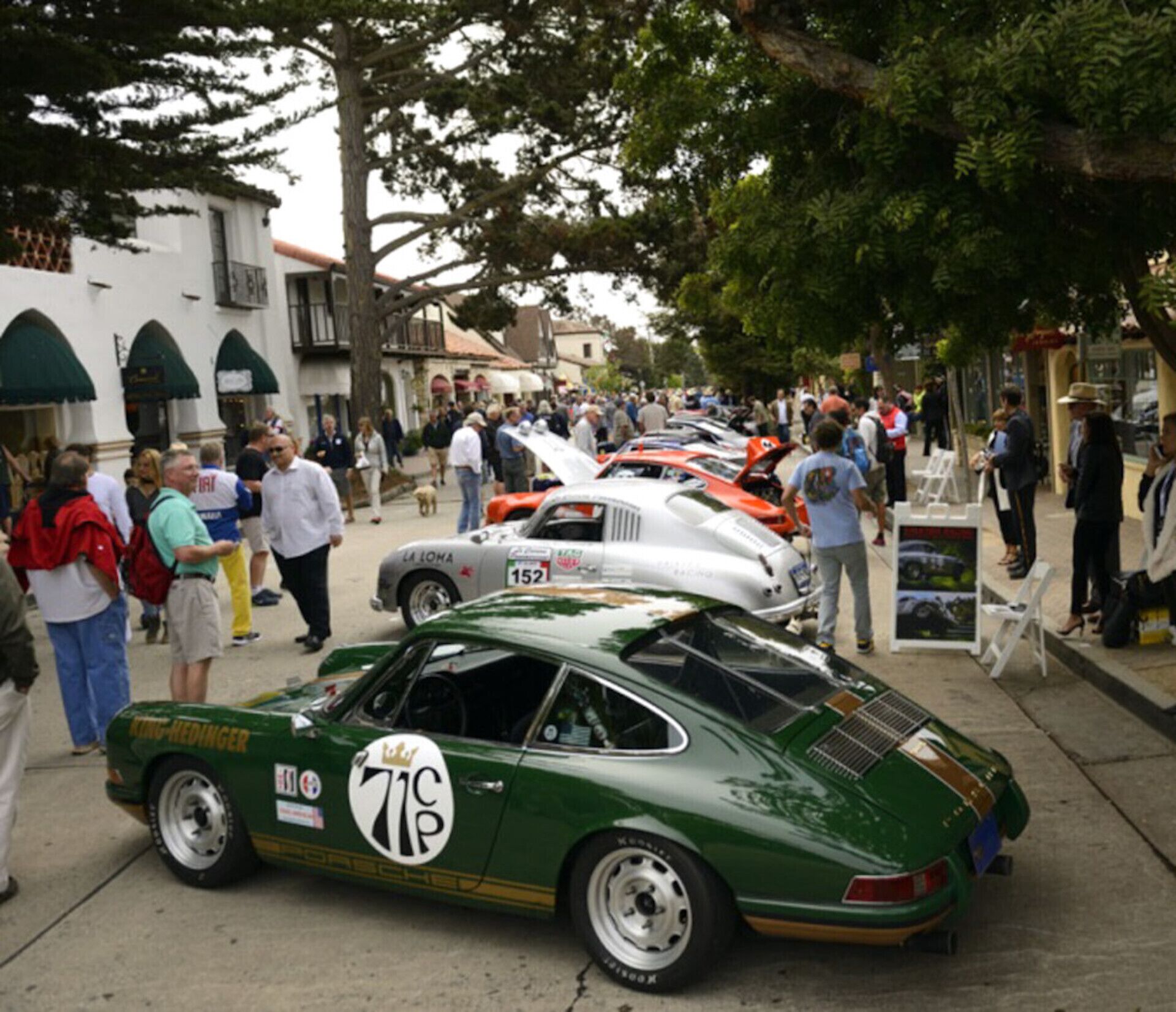 A vintage car event with classic cars parked along a street.