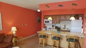 A compact living space with a kitchenette, a dining area with three chairs, a sofa, and a coffee table. - Escape to the Caribbean! Beachfront Condo Starting at Just $145/Night! (Christiansted)