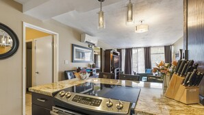 Una cucina moderna con un piano di lavoro in granito, elettrodomestici in acciaio inossidabile e un portacoltelli.