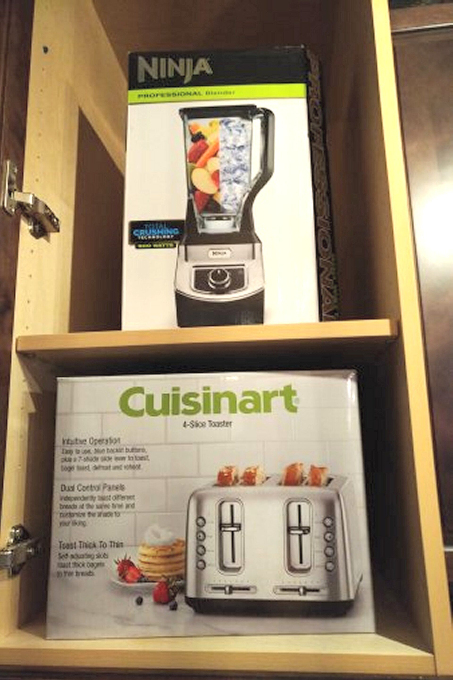 A kitchen cabinet with a Ninja blender and a Cuisinart toaster.
