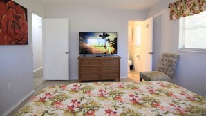 A bedroom with a bed, a dresser, a television, and a chair. - Private Large Pool Getaway Near Siesta Key Gulf Gate Home (Sarasota)