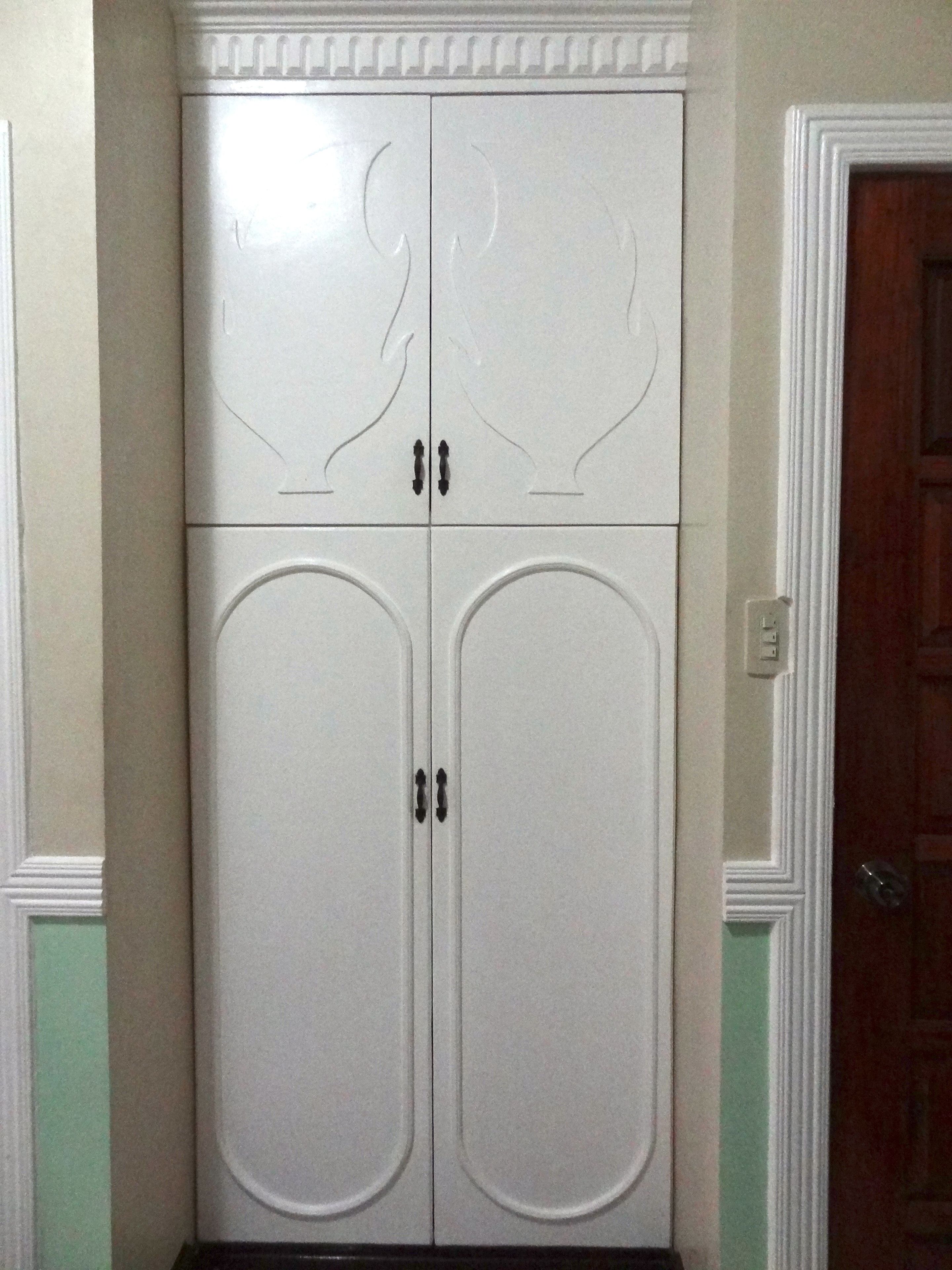 Ein weißer Kleiderschrank mit zwei Türen und einem Spiegelaufsatz.