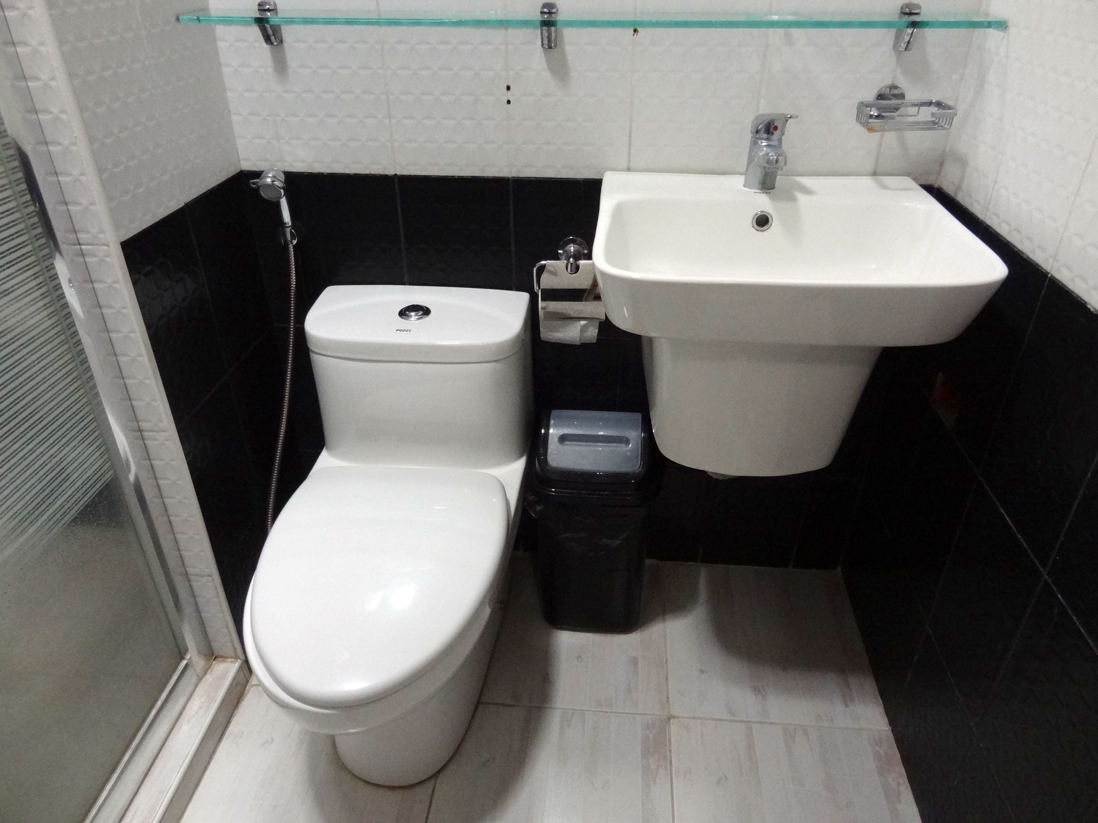 Baño con inodoro, lavamanos y basurero.