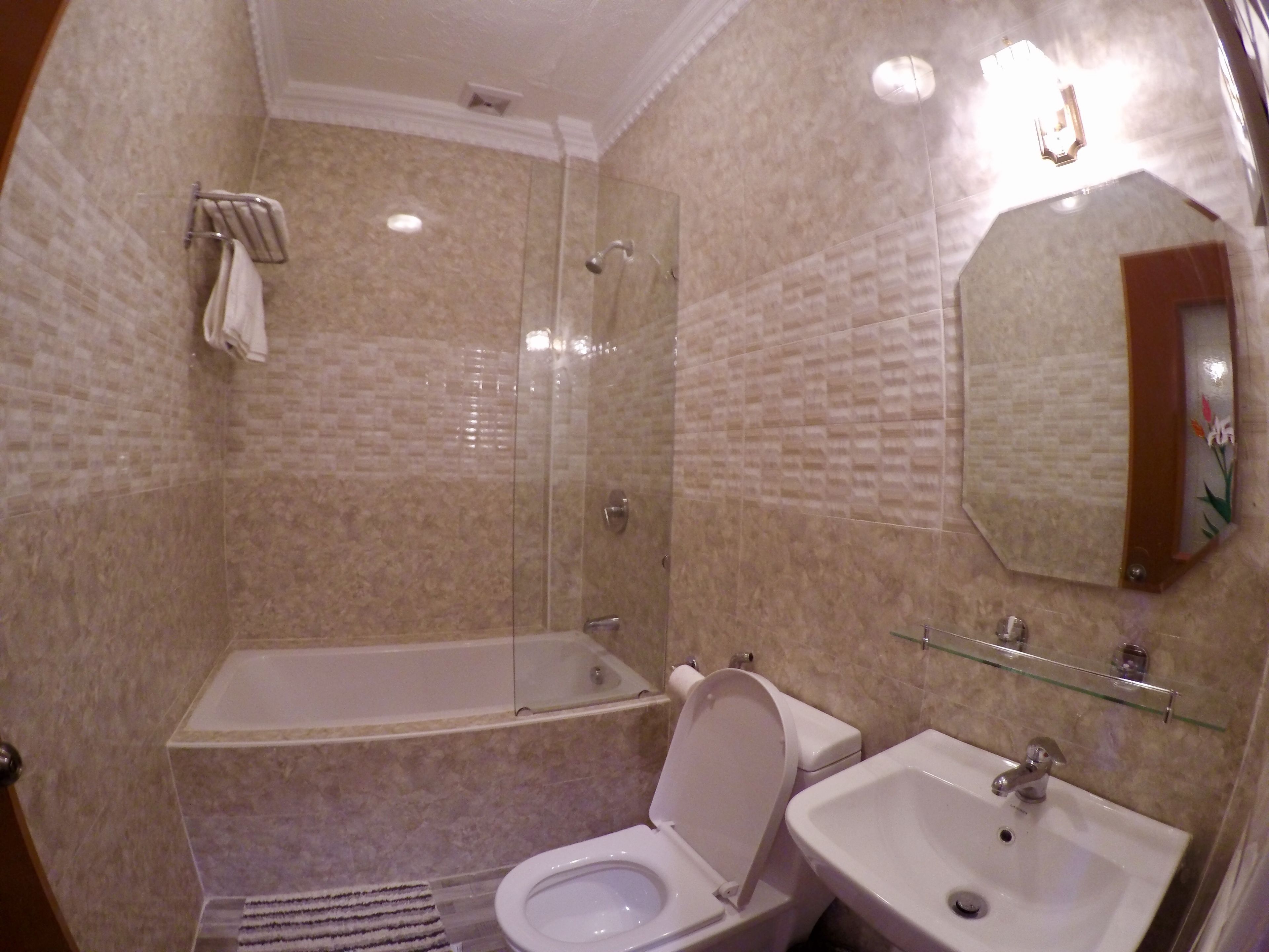 Un baño con bañera, inodoro y lavamanos, todo con accesorios blancos.