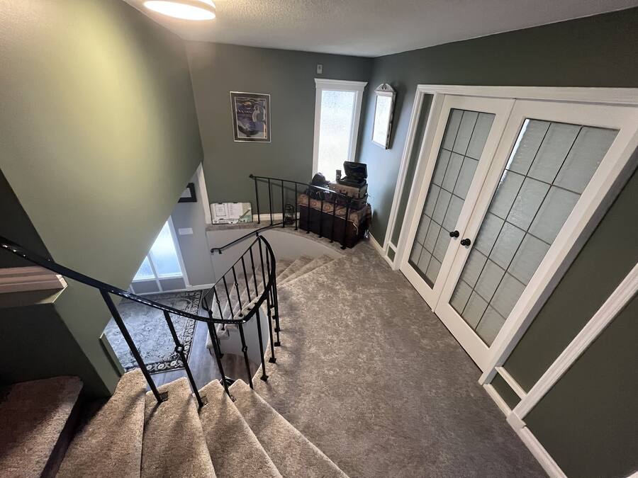 Un escalier menant à un palier d’où l’on peut admirer la vue sur l’extérieur.