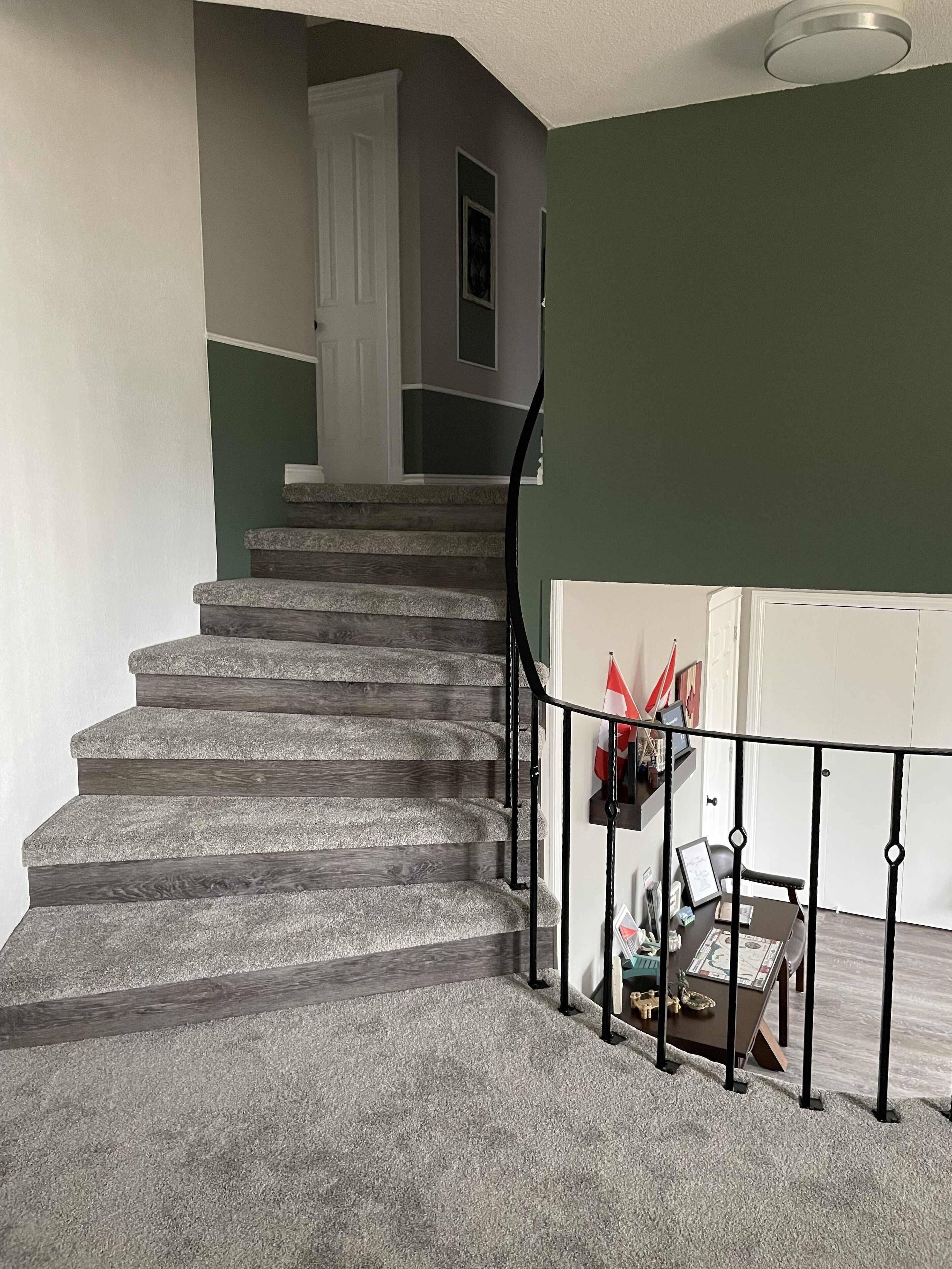 A staircase with a handrail, carpeted steps, and a door at the top.