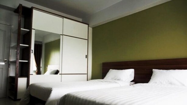 A hotel room with two beds, a wardrobe, and a mirror. - L Residence Songkhla (Songkhla)