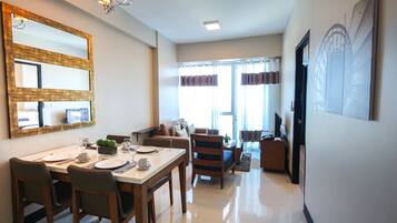 A modern living room with a dining area, a large mirror, and a television.