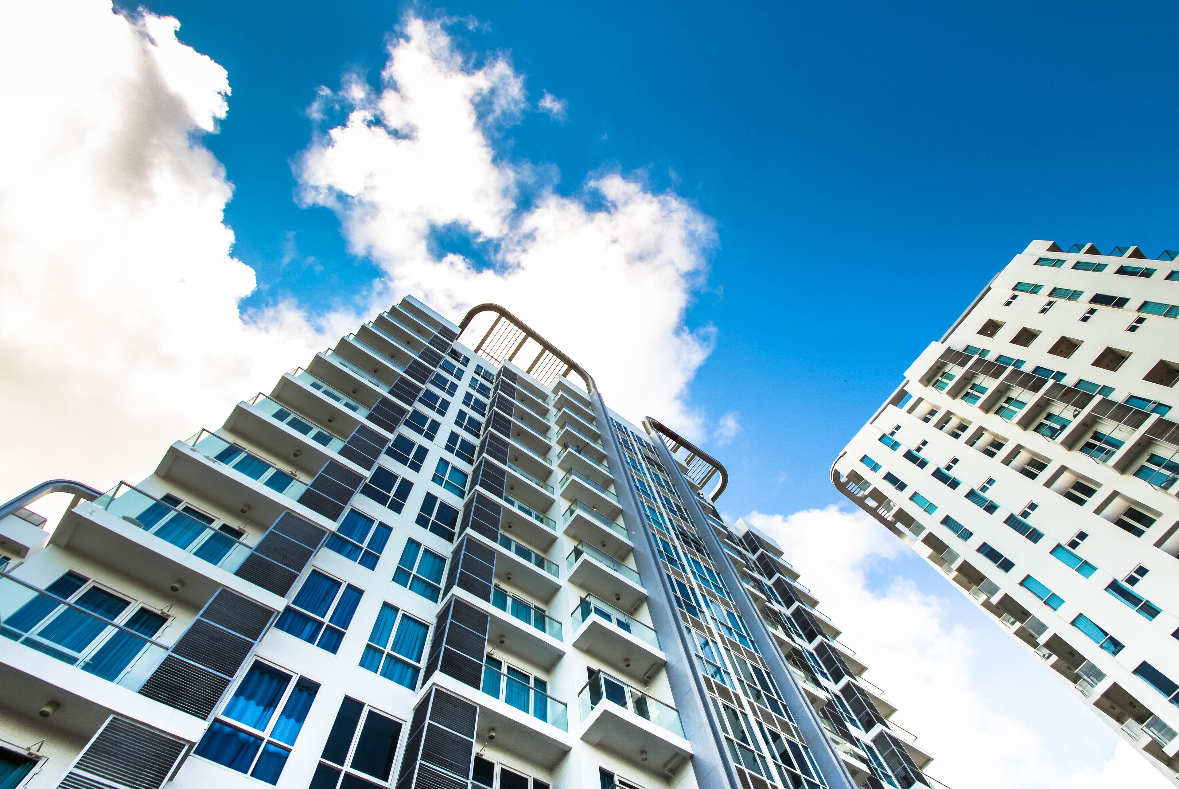 A high-rise building with multiple balconies and a clear sky.
