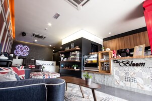 A modern interior with a seating area, a bar, and shelves with various items.