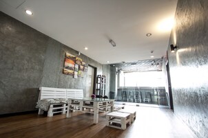 A modern interior with a wooden bench, a glass table, and a white sofa.