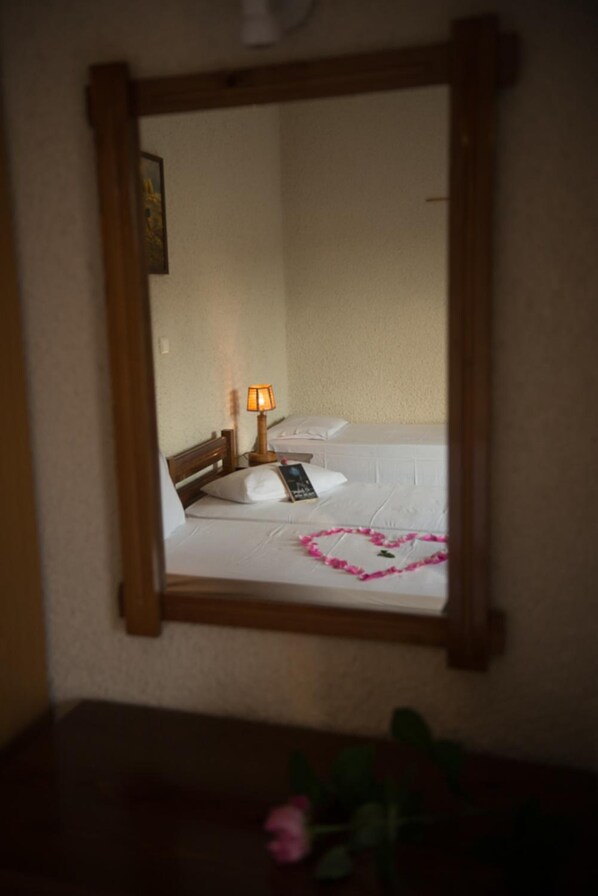 A hotel room with a bed, a bedside lamp, and a heart-shaped decoration on the bed. - Studios Margarita (Messini)