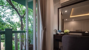 A room with a desk, chair, and a view of greenery outside. - Hanoian Central Hotel & Spa (Hanoi)