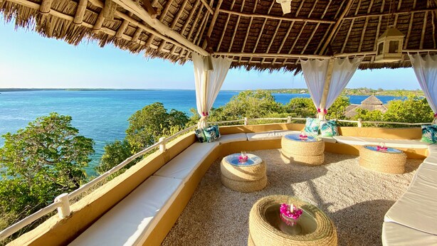 A beachside lounge with thatched roof, wicker furniture, and a view of the sea. - Rock and Sea Resort (Watamu)