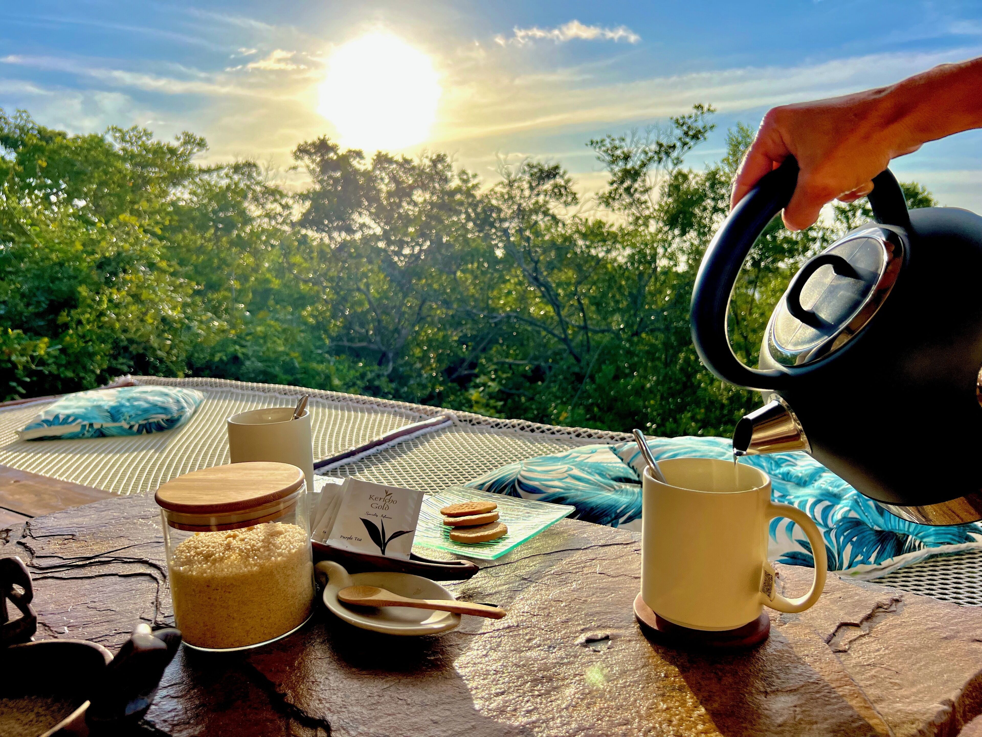 Ein Tisch draußen mit Blick auf Bäume und die Sonne.