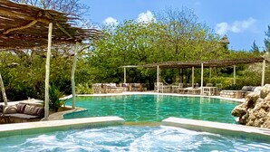A clear blue pool with a wooden pergola and lounge chairs. - Rock and Sea Resort (Watamu)